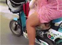 奶妈骑电动车带孩子走光露内裤gif